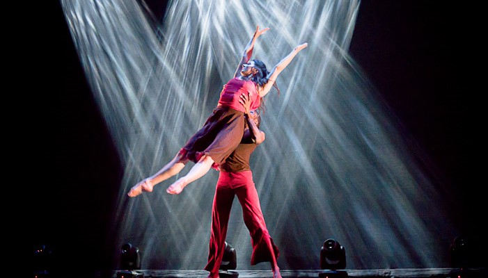 Male dancer lifting female dancer into light